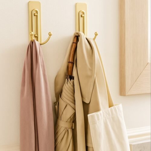 wall hooks. renter-friendly wall hanging solution using satin brass command hooks, featuring coats, tote bag and umbrella